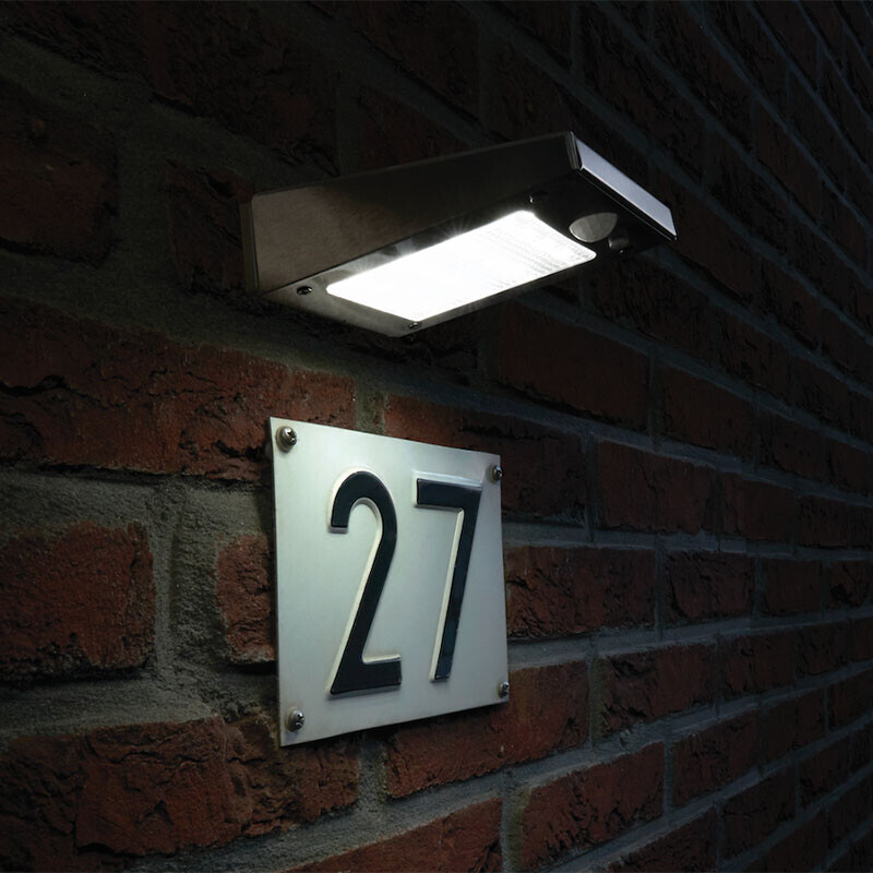 Solar wandlamp verlicht huisnummer op bakstenen muur in het donker