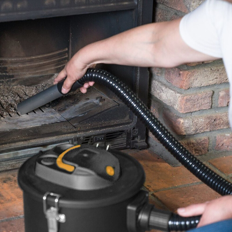 Man gebruikt 800W aszuiger om as uit een houtskoolbarbecue te verwijderen in de tuin.