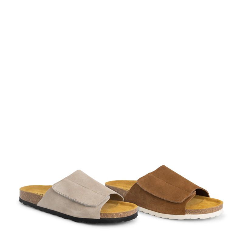 Twee paar suède slippers voor dames in beige en bruin naast elkaar